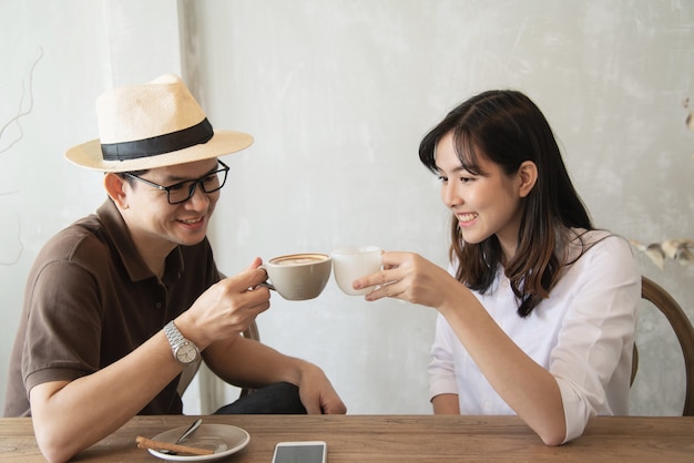 Casual man and woman talking happily while drink coffee 