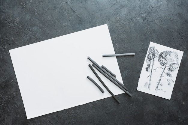 Free photo charcoal stick with drawn paper and black white paper sheet