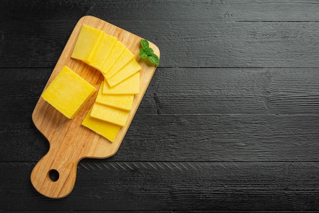 Free photo cheddar cheese on dark wooden surface