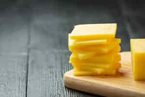 Free photo cheddar cheese on dark wooden surface