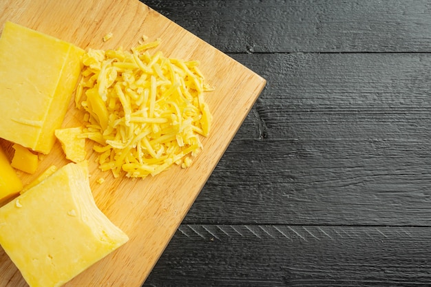 Free photo cheddar cheese on dark wooden surface