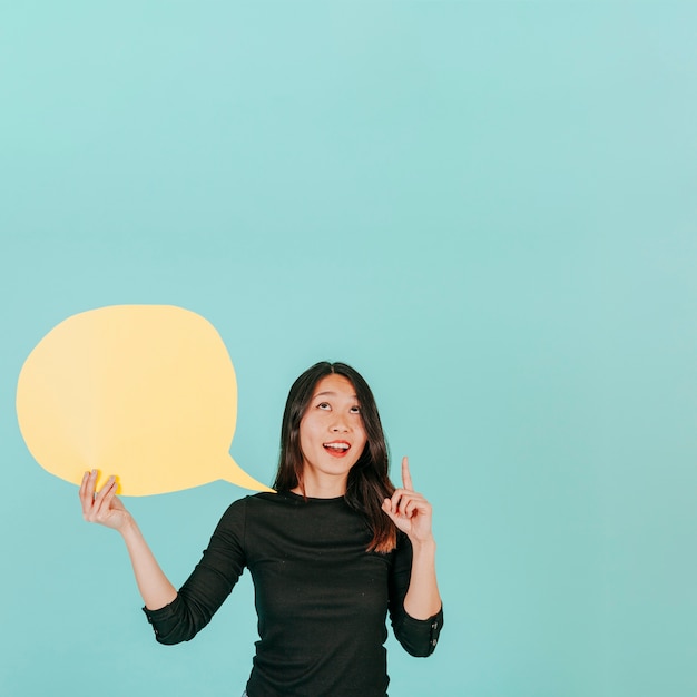 Free Photo cheerful woman with speech bubble pointing up