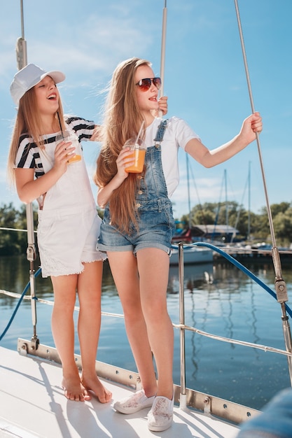 Foto gratuita i bambini a bordo dello yacht del mare bevono succo d'arancia