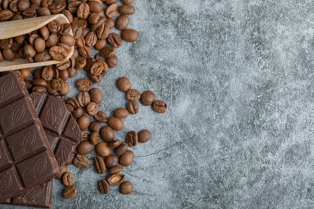 Foto gratuita barrette di cioccolato con chicchi di caffè su grigio.