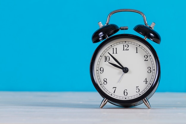 Close-up of alarm clock with blue background