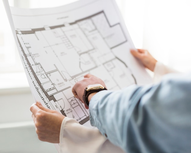 Free photo close-up of architect's hand discussing plan on blueprint