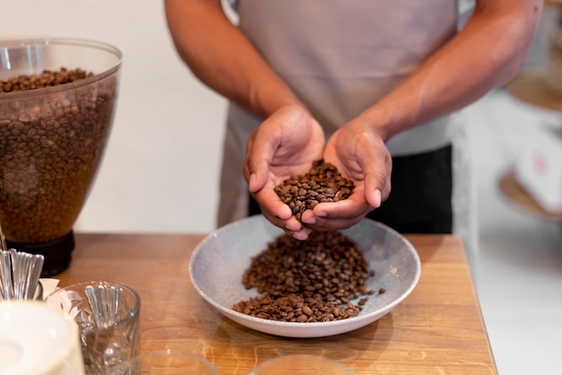 Free photo close up barista holding coffee beans