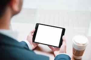 Free photo close-up of a businessman looking at digital tablet with white screen display in caf�