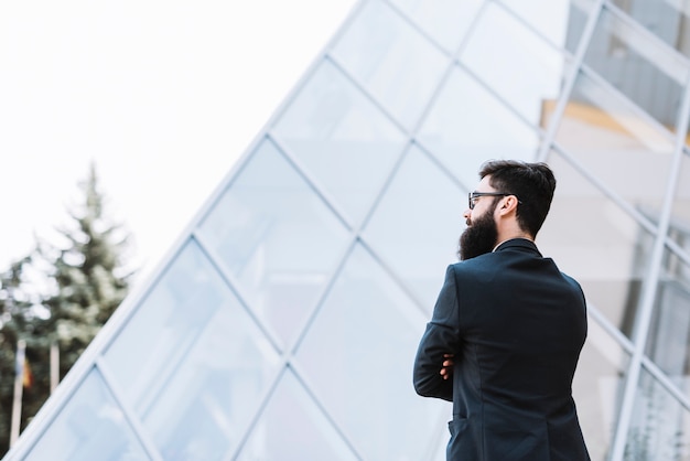 Close-up of a businessman standing in front of corporate building