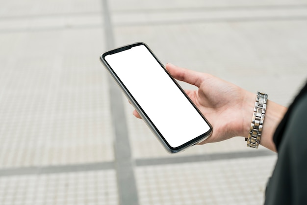 Free photo close-up of businesswoman's hand holding smartphone displaying white screen