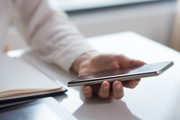 Free photo close-up of businesswomans hand holding mobile phone