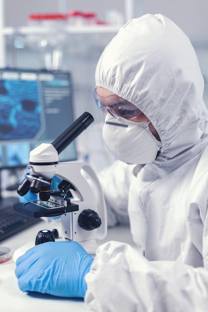 Free Photo close up of chief researcher scientist adjusts microscope in time of coronavirus experiment