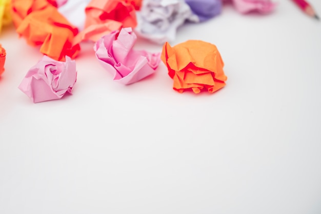 Free Photo close-up of colorful crumpled paper on white desk