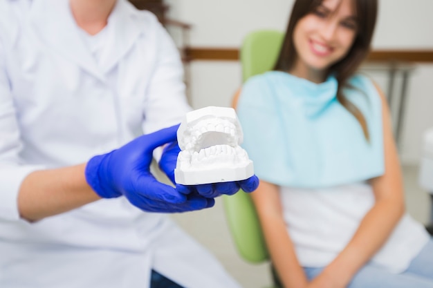 Free photo close-up of dentist holding dentures with patient