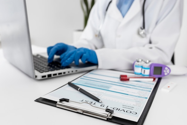 Free photo close-up doctor working on laptop