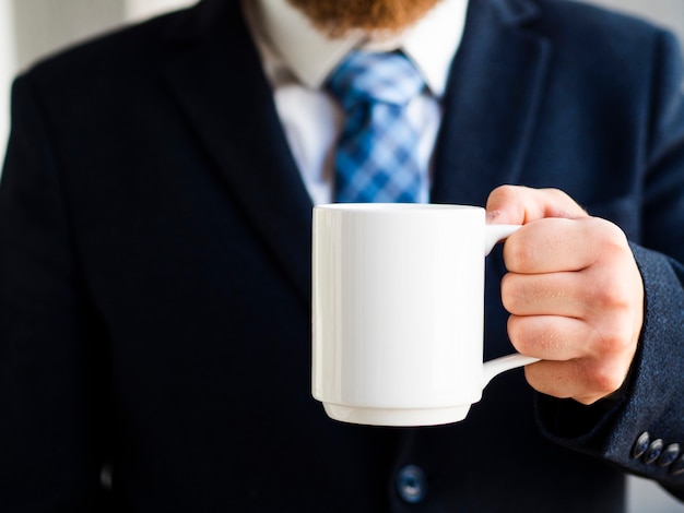 Free Photo close-up elegant man holding up white mug