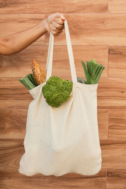 Close up hand holding bag with vegetables