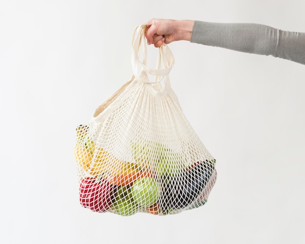 Free photo close-up hand holding reusable bag with vegetables and fruits