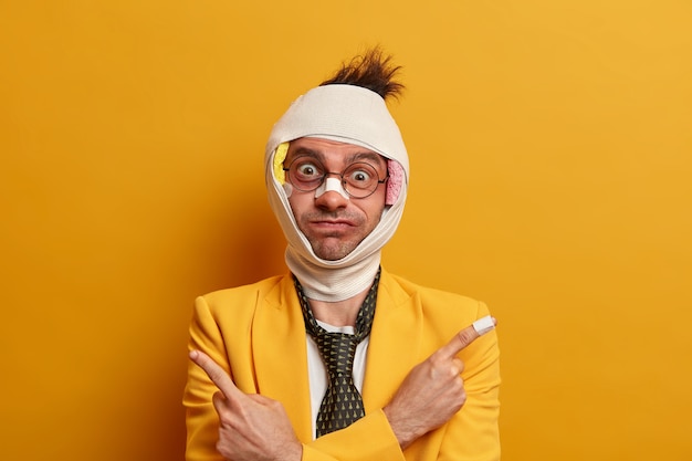 Free photo close up on injured man with dark bruise under eyes and brain concussion, wears bandage