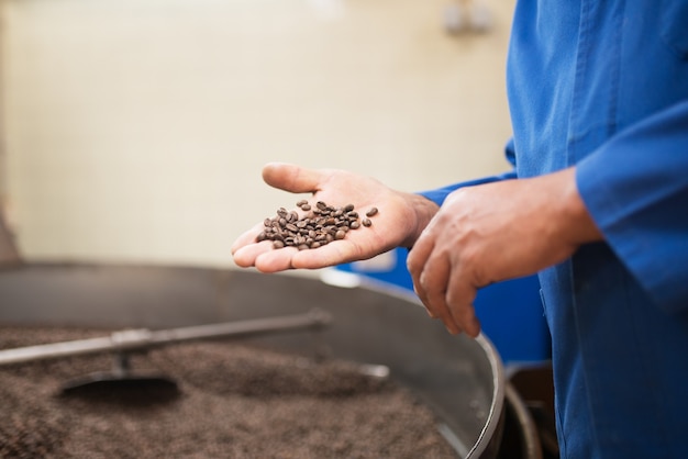 Free photo close-up of man holding roasted coffee beans