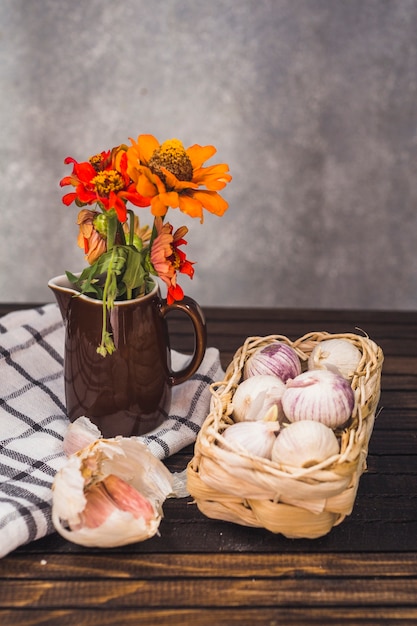 Free Photo close-up of onions; garlic cloves; flower and cloth on wooden tabletop