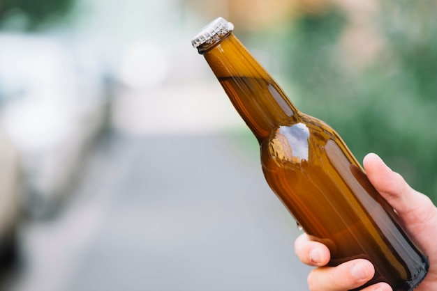 Free photo close-up of a person holding beer bottle