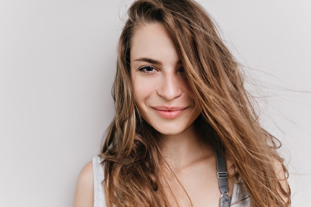 Free photo close-up portrait of european woman with big dark eyes isolated. photo of charming girl with light-brown hair posing with smile.