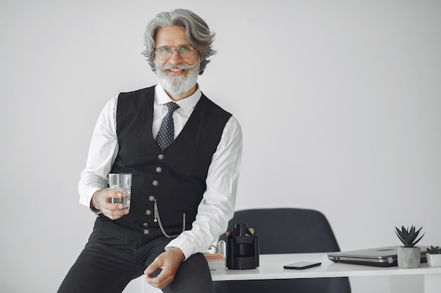 Foto gratuita close up ritratto di ghignare uomo vecchio stile. nonno con un bicchiere d'acqua.