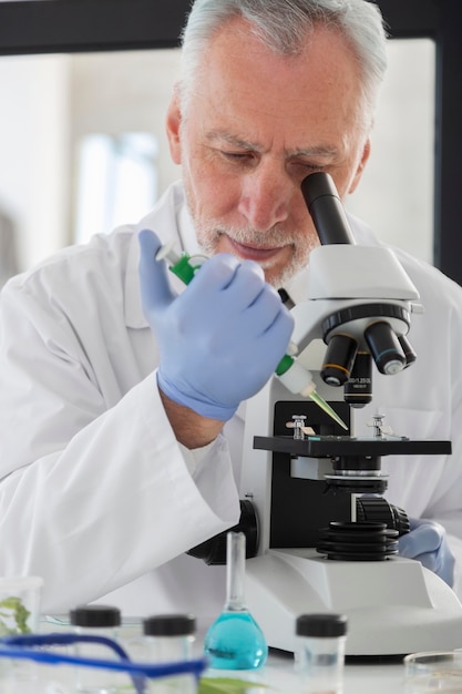 Free Photo close up scientist looking through microscope