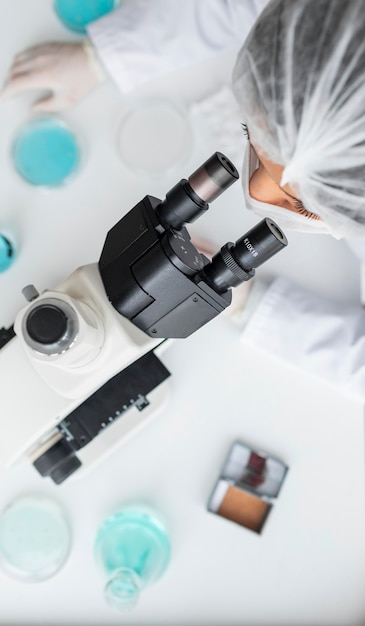 Free photo close up scientist looking through ocular lens