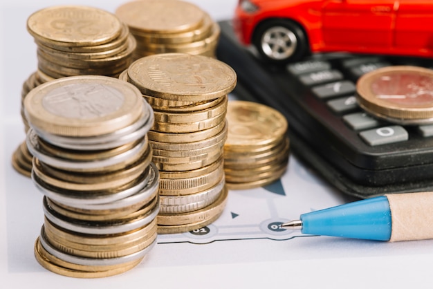 Free photo close-up of stacked coins; pen and calculator