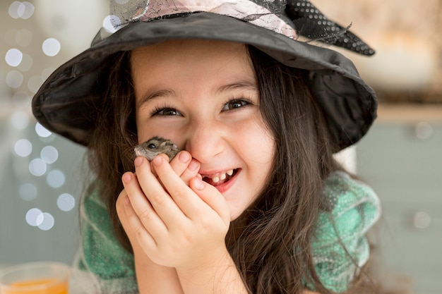 Free photo close-up view of cute little girl holding a hamster