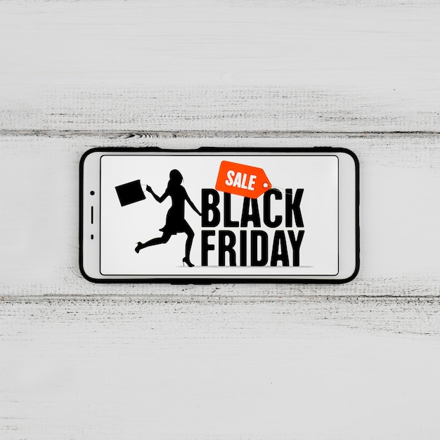 Free photo close-up view of phone with black friday message on wooden table