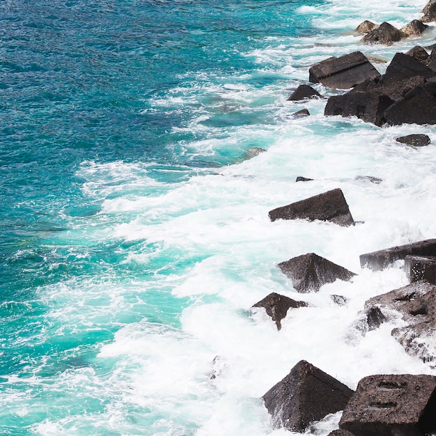 Free photo close-up wavy water at rocky seashore