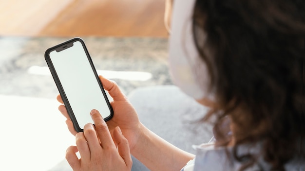 Free photo close up woman holding smartphone