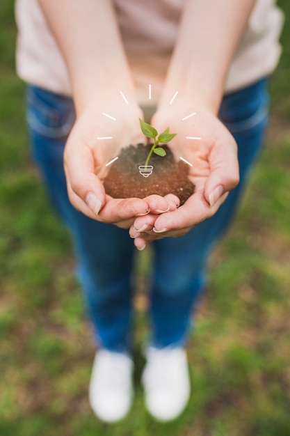 Free photo close up woman holding soil with plant