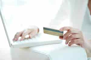 Free photo close-up of woman shopping online with credit card and laptop