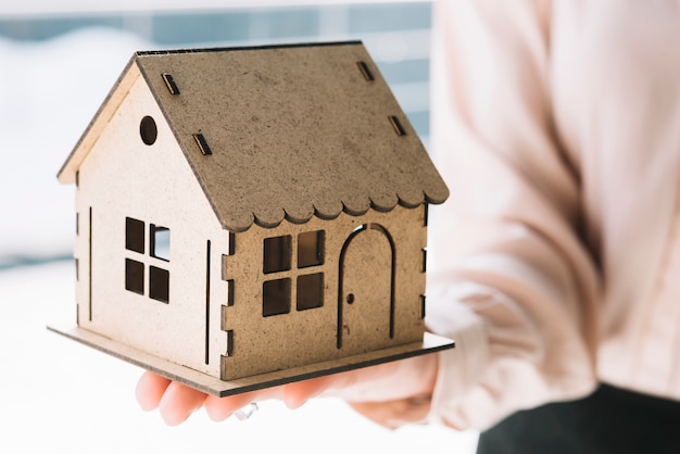 Close-up woman showing toy house