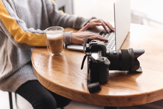 Free Photo close up of woman typing on laptop in coffee shop