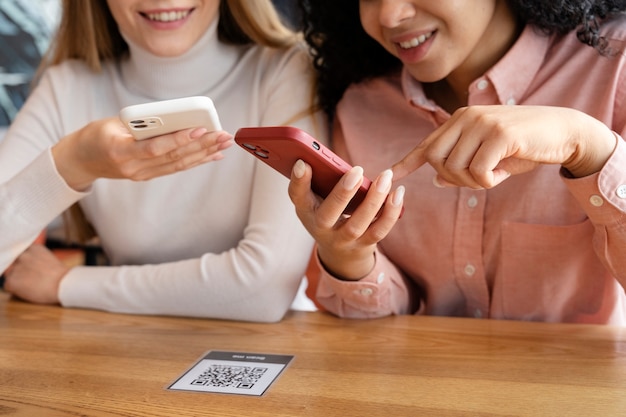 Free photo close up women holding smartphones