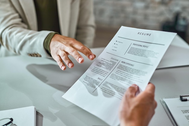 Free photo closeup of a candidate giving his cv while applying for a job in the office