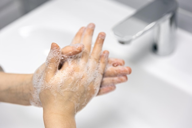 Free photo closeup the child washes his hands in the bathroom