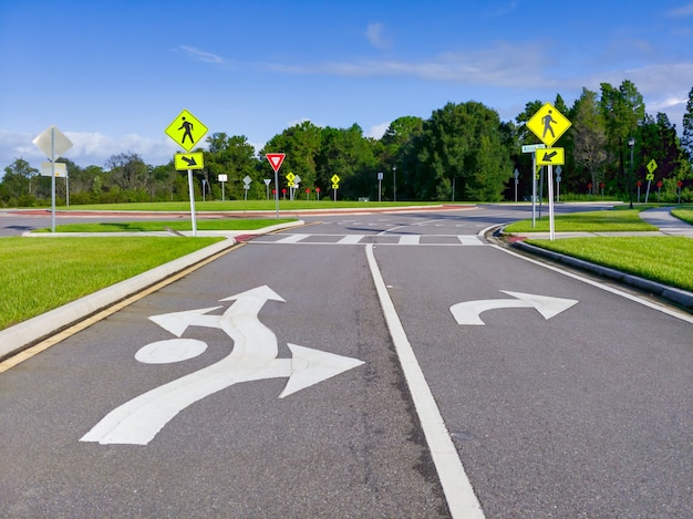 Free photo cluster of street signs and road markings at an entrance to a loop