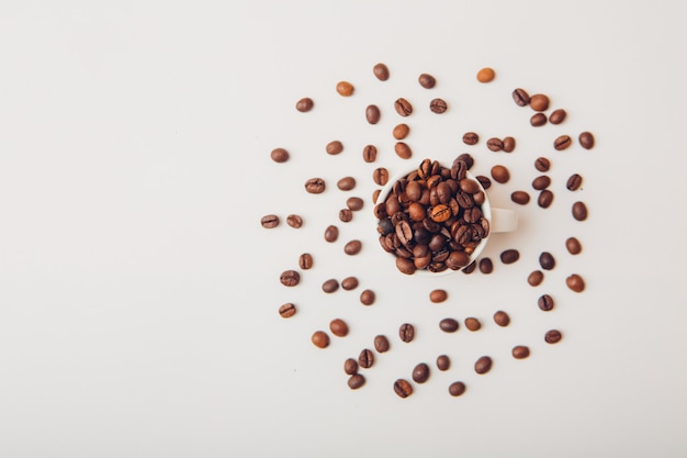 Free photo coffee beans in a cup top view on a white table