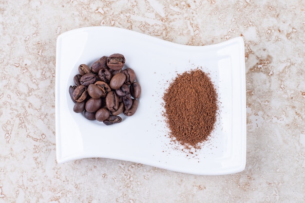 Free photo coffee beans and ground coffee powder on a fancy platter