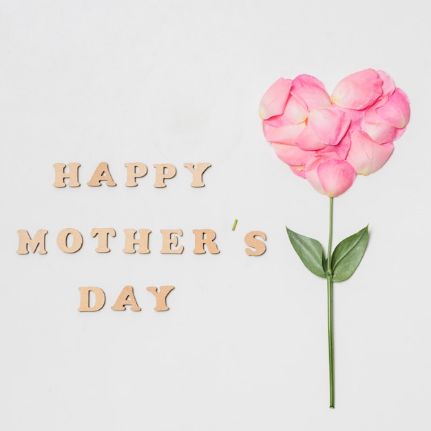 Free photo composition of happy mothers day title near pink bloom in form of heart