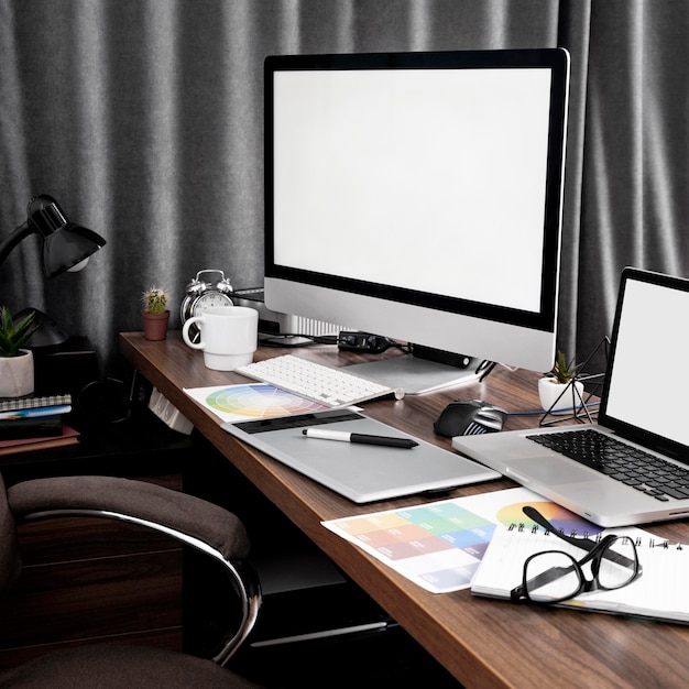 Free Photo computer screen and laptop on office workspace with color palettes