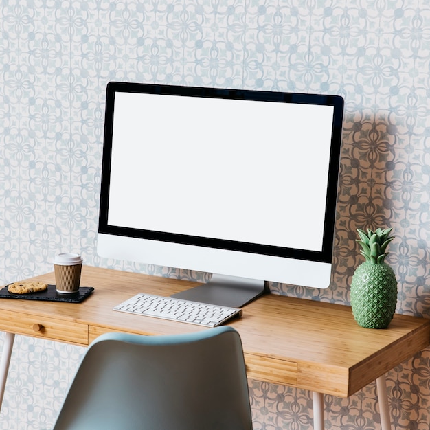 Free Photo computer with cookies and disposal cup on wooden desk