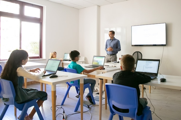 Free photo confident teacher explaining lesson to pupils