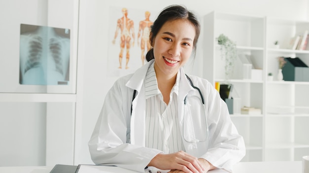 Foto gratuita fiducioso giovane medico femminile asiatico in uniforme medica bianca con lo stetoscopio